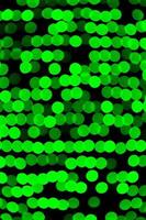 Unfocused abstract green bokeh on black background. defocused and blurred many round light photo