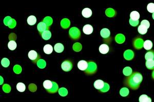 Unfocused abstract colourful bokeh black background. defocused and blurred many round green light photo