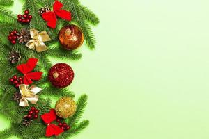 conjunto de bolas festivas, abeto y adornos navideños sobre fondo colorido. vista superior del concepto de adorno de año nuevo con espacio de copia foto