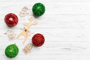 New Year composition made of baubles, reindeer and other decorations on wooden background. Christmas time concept with empty space for your design photo