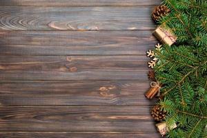 Christmas background with fir tree and gift box on wooden table. Top view with copy space for your design photo