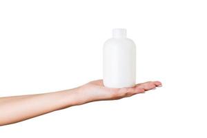 Female hand holding cream bottle of lotion isolated. Girl give tube cosmetic products on white background photo