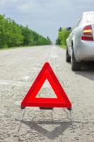 Red triangle of a car on the road. Breakdown of the car in bad weather photo