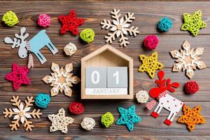 Top view of calendar on Christmas wooden background. The first of January. New Year toys and decorations. Holiday concept photo