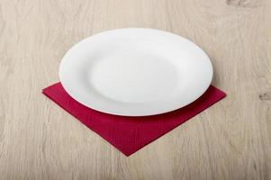 Empty white plate on wooden table photo