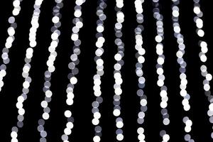 Abstract glitter sparkle bokeh defocused on black background. many round light on background photo