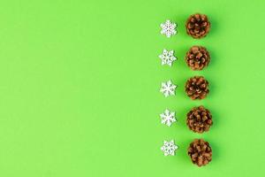 Top view of New Year ornament made of white snowflakes and pine cones on colorful background. Winter holiday concept with empty space for your design photo