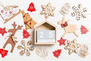 Top view of calendar on Christmas wooden background. The twenty fifth of December. New Year toys and decorations. Holiday concept photo