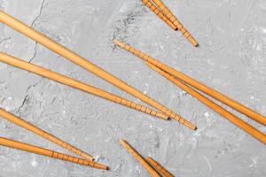 Many bamboo chopsticks on black cement stone background, top view with copy space. a lot of sushi sticks in the form of an ornament photo