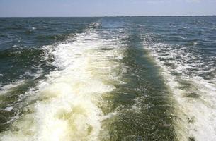 bow wave of fast motor boat on the sea and picturesque blue sky. photo