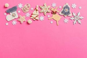 Top view of holiday decorations and toys on pink background. Christmas ornament concept with empty space for your design photo