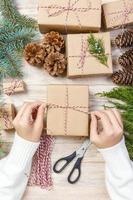 Girl hands wrapping New year gift, gift wrapping process, needlework, creativity photo