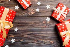 Top view of Christmas background made of gift boxes and snowflakes on wooden background. New year holiday concept with copy space photo