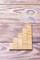 A wooden blocks cube over black wooden textured background with copy space for add word text title. Concept or conceptual Wood block stair or five steps. Cubic photo