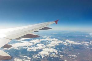 Wing of an airplane. Traveling concept. Aircraft wing on the clouds photo