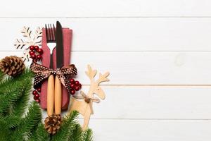 Top view of flatware tied up with ribbon on napkin on wooden background. Christmas decorations and reindeer with empty space for your design. New Year holiday concept photo