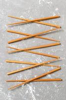 Many bamboo chopsticks on black cement stone background, top view with copy space. a lot of sushi sticks in the form of an ornament photo