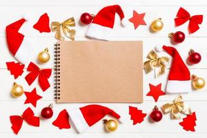 Top view of notebook on wooden background made of Christmas decorations. New Year concept photo