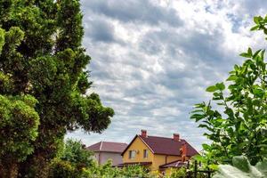 overcast sky. Wooden house building, green field with house in overcast day. photo