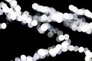 Unfocused abstract white bokeh on black background. defocused and blurred many round light photo
