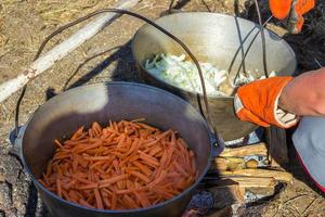 Cooking plov in the cauldron. Only the meat in the cauldron. Field kitchen. Eastern cuisine. photo