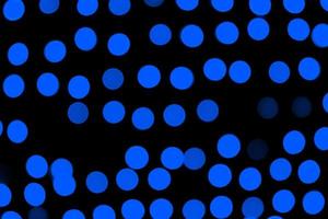 Unfocused abstract dark blue bokeh on black background. defocused and blurred many round light photo