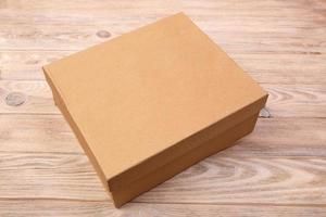 Craft cardboard package box presented on wooden table. top view photo