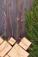 Christmas fir tree branches with gift box on dark rustic wooden background with copy space for text photo