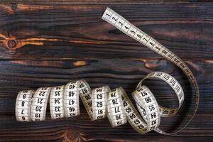 Tailoring Meter White measuring tape on wooden background photo