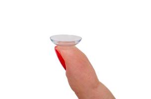 Female finger with contact lens isolated on white photo