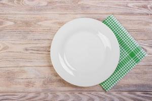 Empty plate with napkin on grey wooden table photo