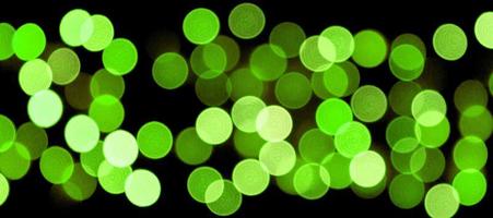 Unfocused abstract colourful bokeh black background. defocused and blurred many round green light photo