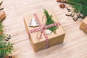 Christmas background with fir tree and gift box on wooden table. Top view with copy space for your design. Toned photo