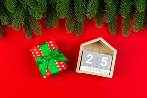 Top view of wooden calendar, gift box and fir tree on colorful background. The twenty fifth of December. Christmas time with copy space photo