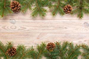 Christmas gray wooden background with fir tree frame and cones copy space. top view empty space for your design photo