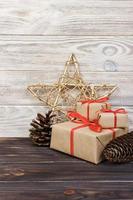 Christmas background with Christmas gift and star on wooden background with cones. Xmas and Happy New Year composition