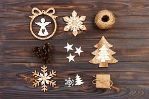 composición navideña. copos de nieve de navidad, árbol de navidad y ángel en un marco sobre un fondo de madera. decoraciones de madera de año nuevo foto