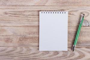 Blank notepad with pen on office wooden table photo