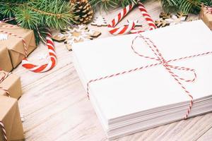 paquete en sobre con ramas de abeto y decoración navideña sobre un fondo de madera. tonificado