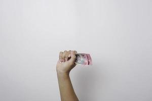 A portrait of a hand grabbing bunch of money in Indonesian Rupiah photo