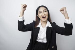 A young Asian businesswoman with a happy successful expression wearing black suit isolated by white background photo