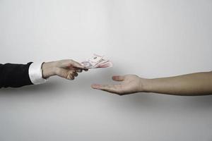 A portrait of businessman giving money in Indonesian Rupiah for business deal or payment or charity photo