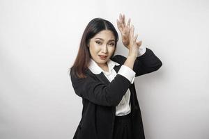 Young Asian business woman isolated on white background, looks depressed, face covered by fingers frightened and nervous. photo