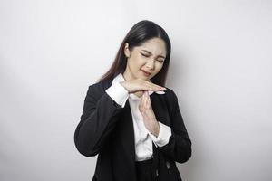 mujer de negocios asiática hispana con traje negro haciendo gestos de tiempo fuera con las manos, cara frustrada y seria foto