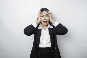 A portrait of an Asian business woman wearing a black suit isolated by white background looks depressed photo