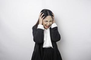 A portrait of an Asian business woman wearing a black suit isolated by white background looks depressed photo