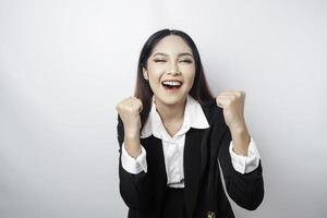 una joven mujer de negocios asiática con una expresión feliz y exitosa con traje negro aislada de fondo blanco foto