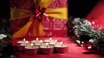 Christmas candle lights and gift on red background decoration video