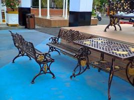 brown gold iron carving bench with arabic architecture in madiun indonesia park, sunny weather. photo