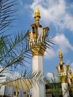 brown gold white color mosque minaret with arabic architecture in madiun indonesia park, sunny weather. photo